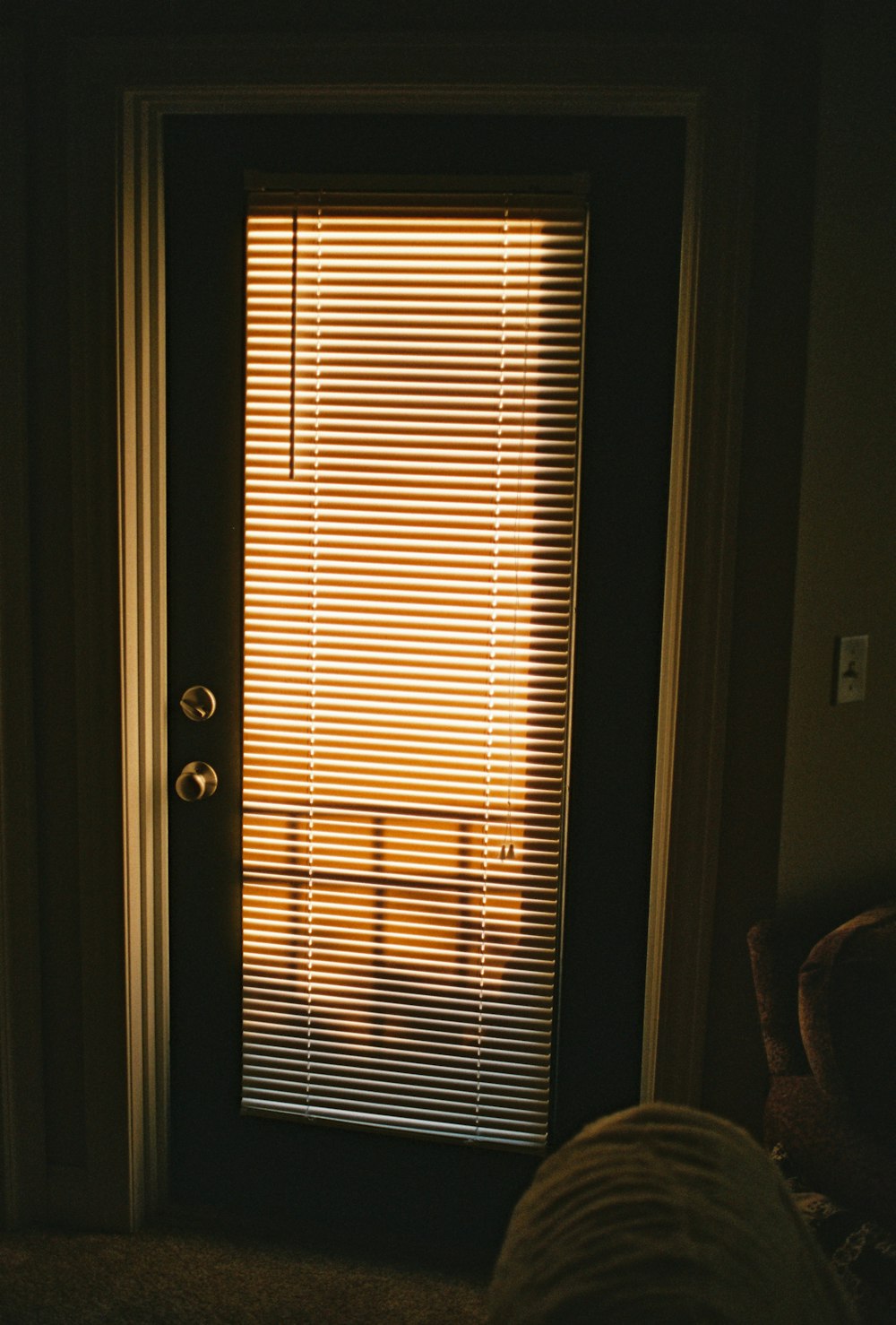 a door with the blinds closed in a dark room