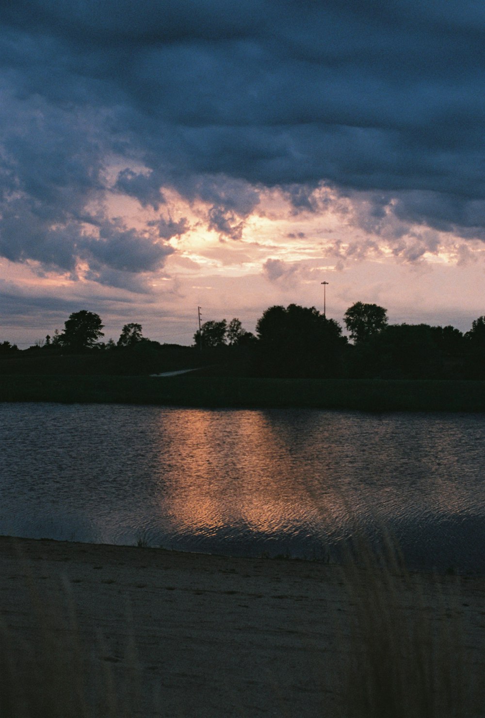 a body of water sitting under a cloudy sky