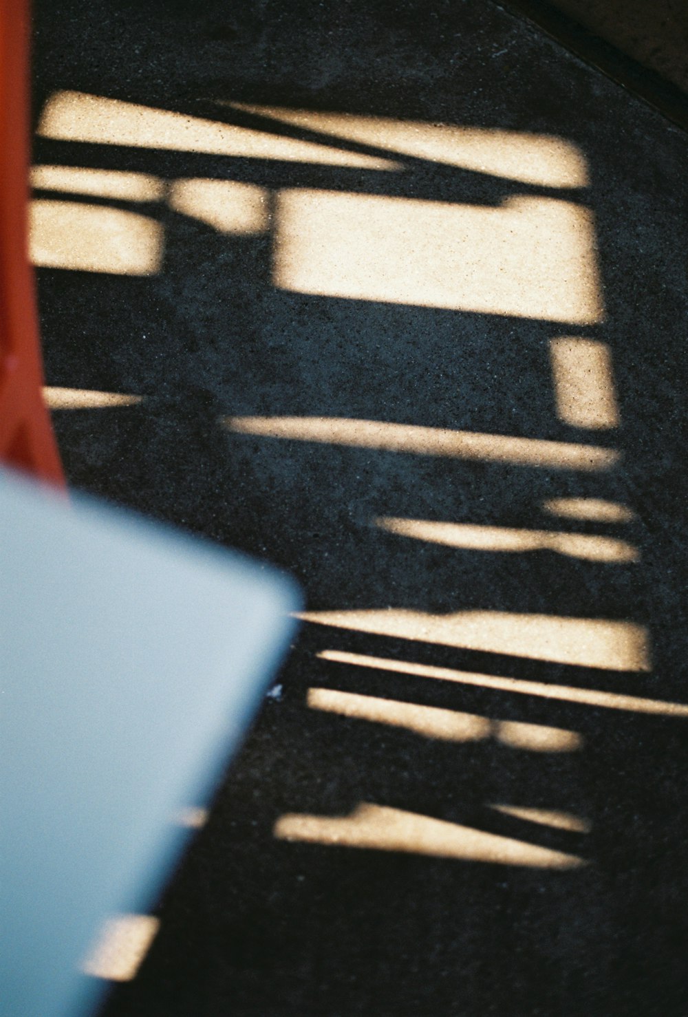 the shadow of a bench on the ground