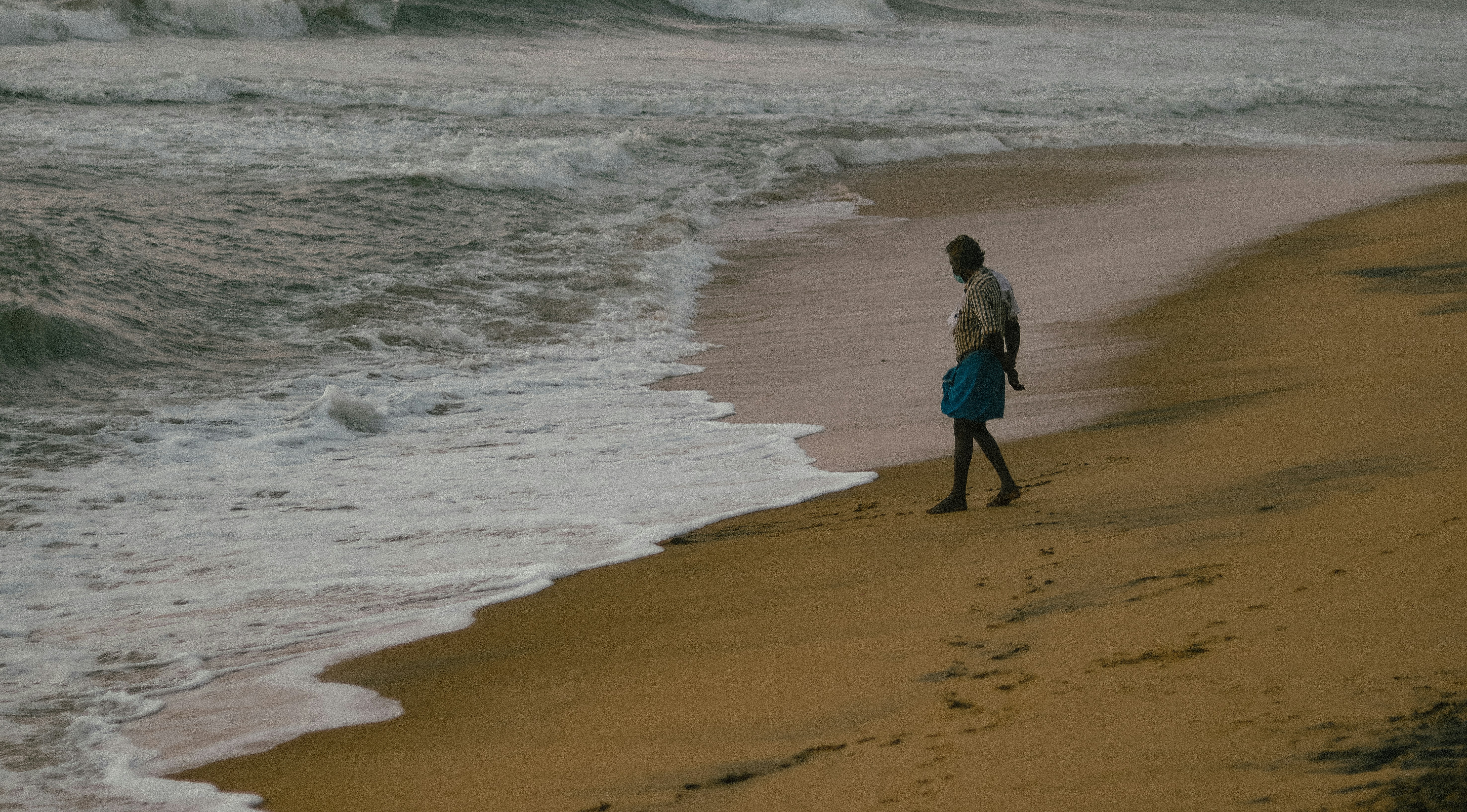 a person standing on a beach next to the ocean