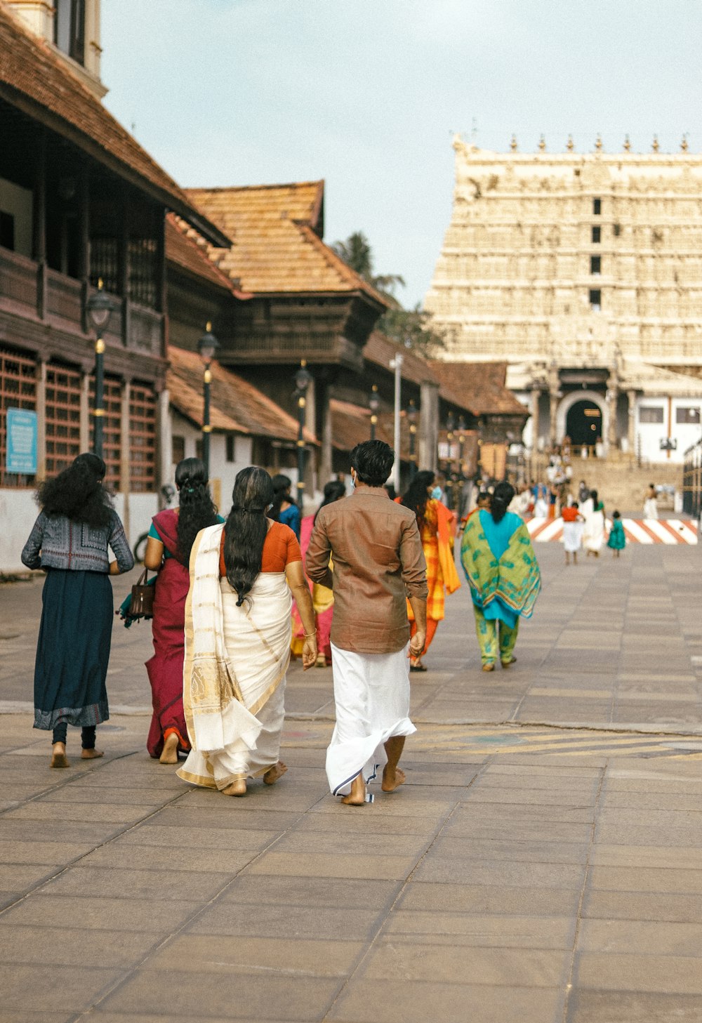 a group of women walking down a street next to tall buildings