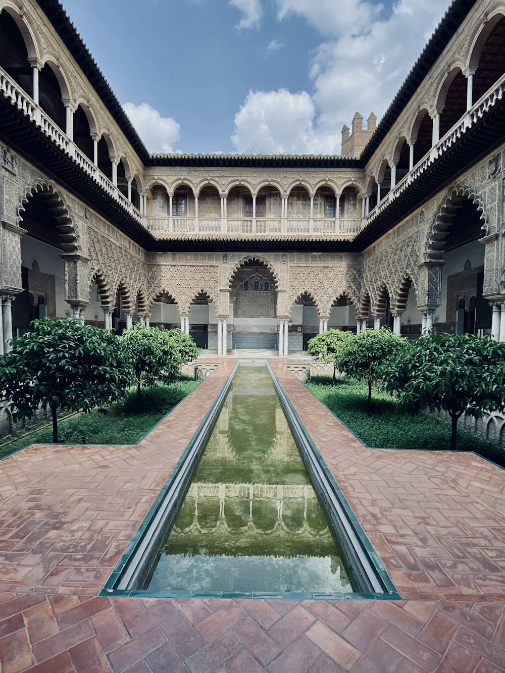 a long pool of water in a courtyard