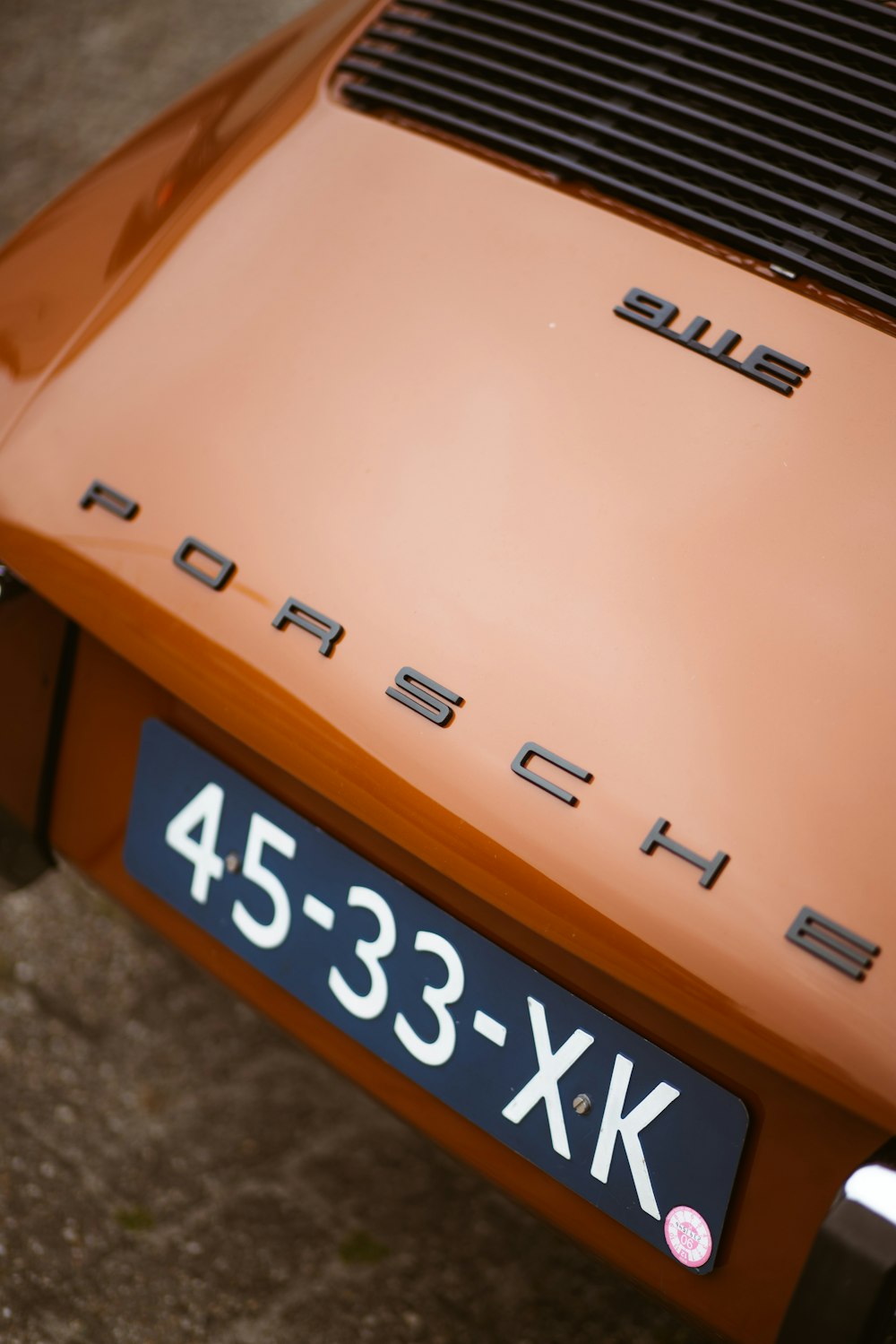 a close up of the front of an orange porsche