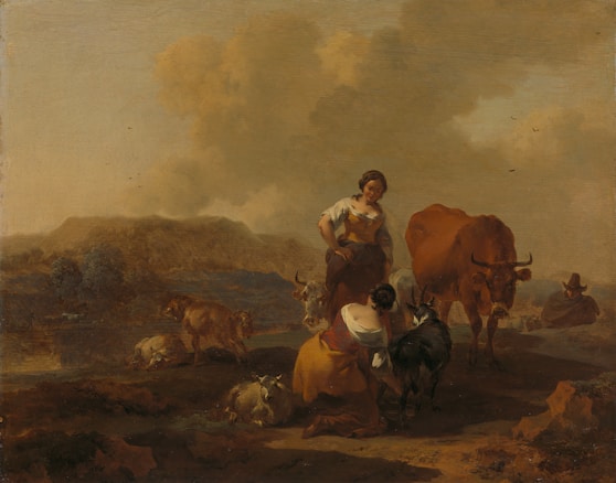 Two women are tending to livestock in a pastoral setting. One woman is milking a goat while another stands beside her, surrounded by goats and cattle. In the background, more animals graze near hills under a vast sky with fluffy clouds.