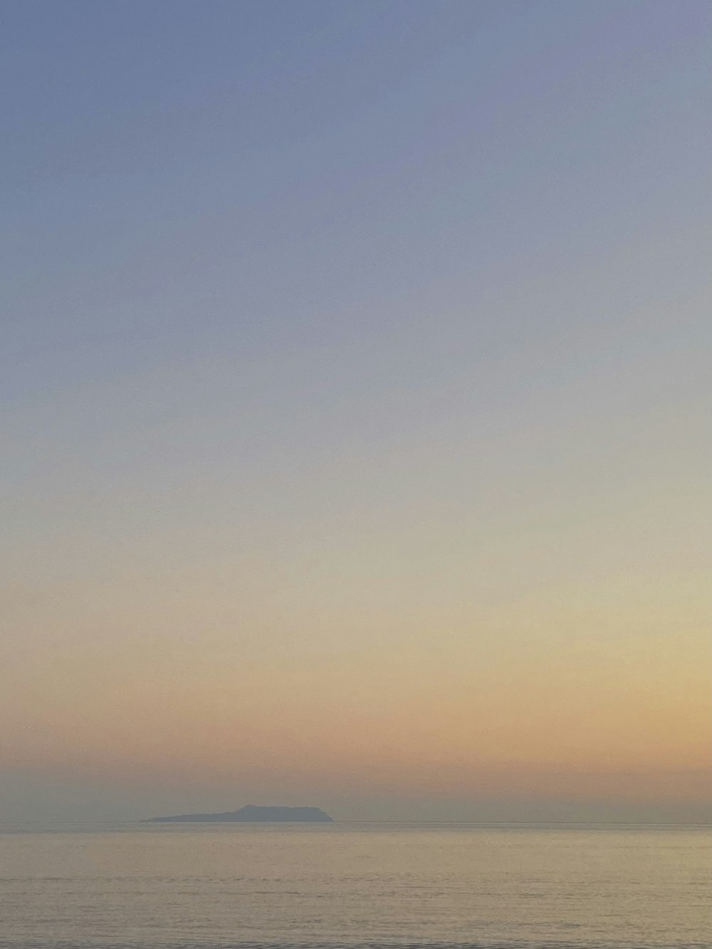 Una persona caminando por la playa al atardecer