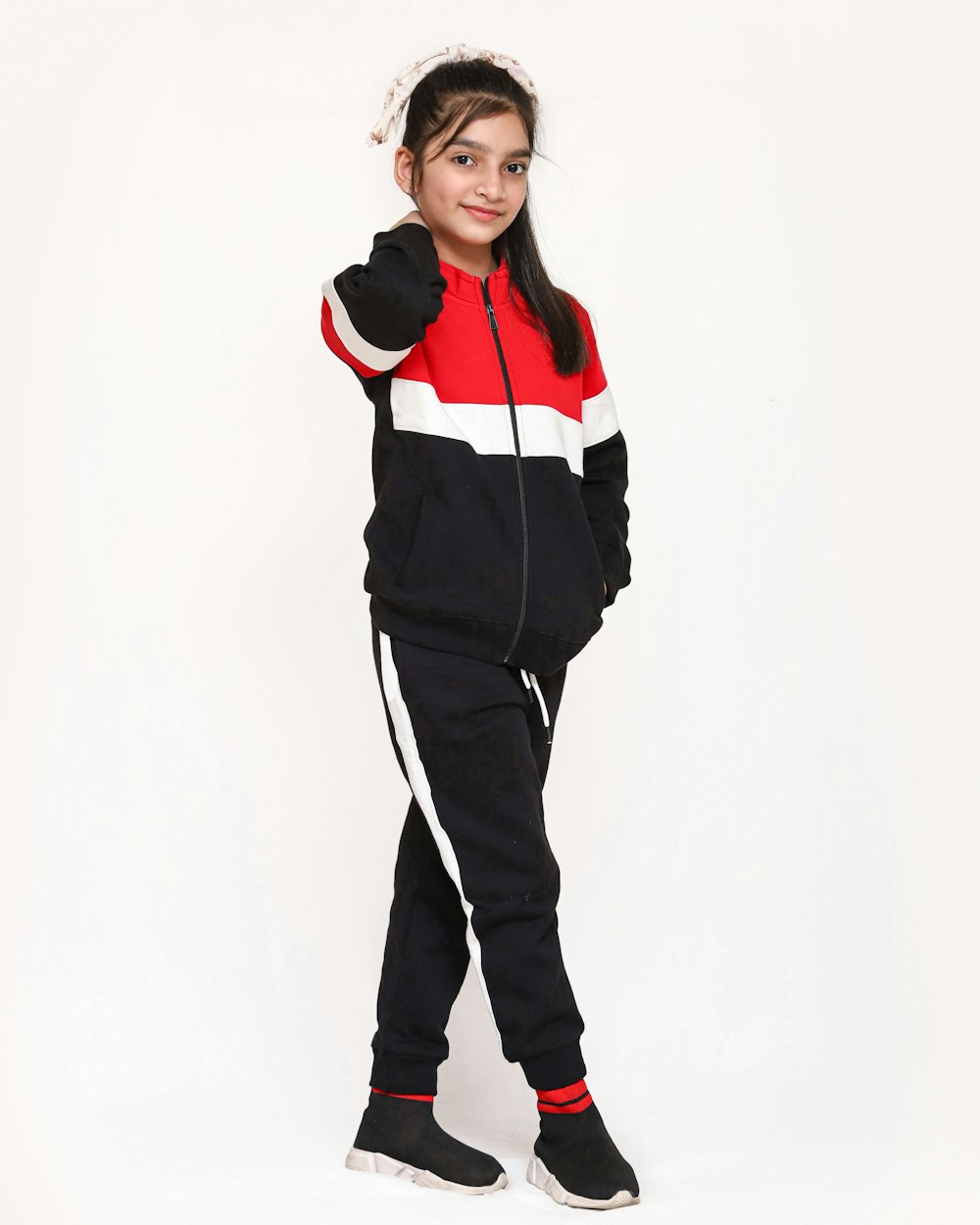 a young girl wearing a black and red hoodie