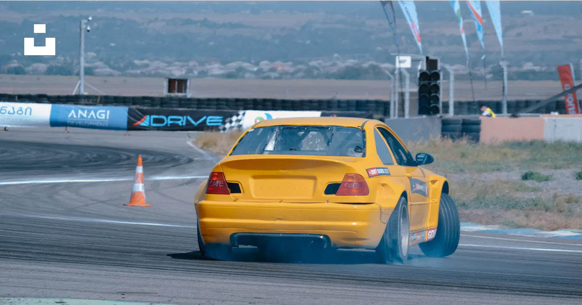A yellow car driving down a race track photo – Free Rustavi ...