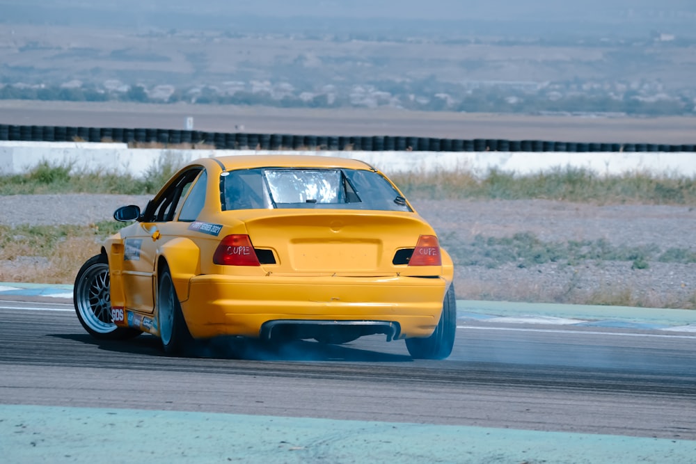 a yellow car driving down a race track