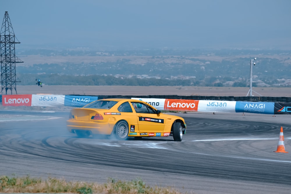 a yellow car driving on a race track