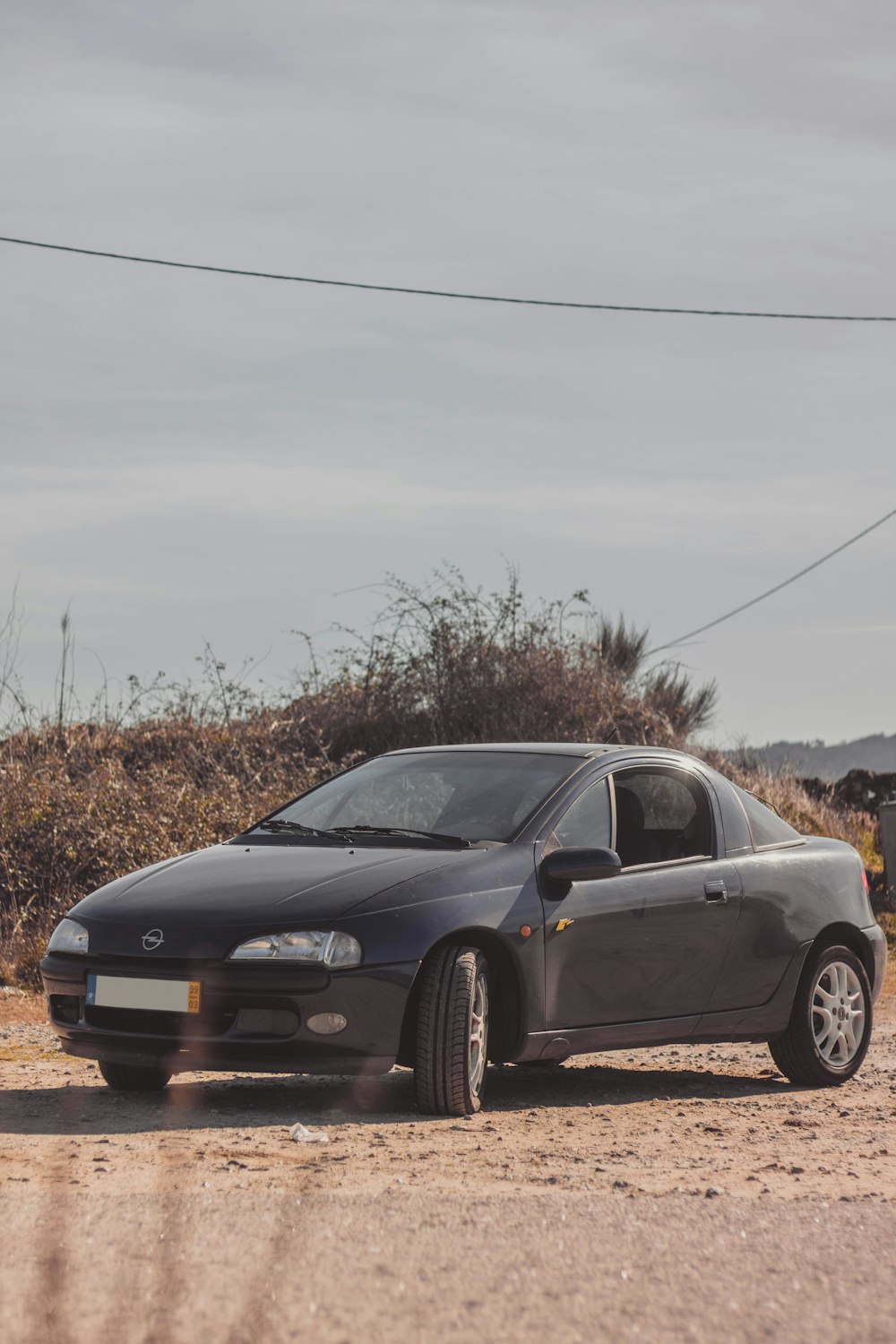 a car parked on the side of a dirt road