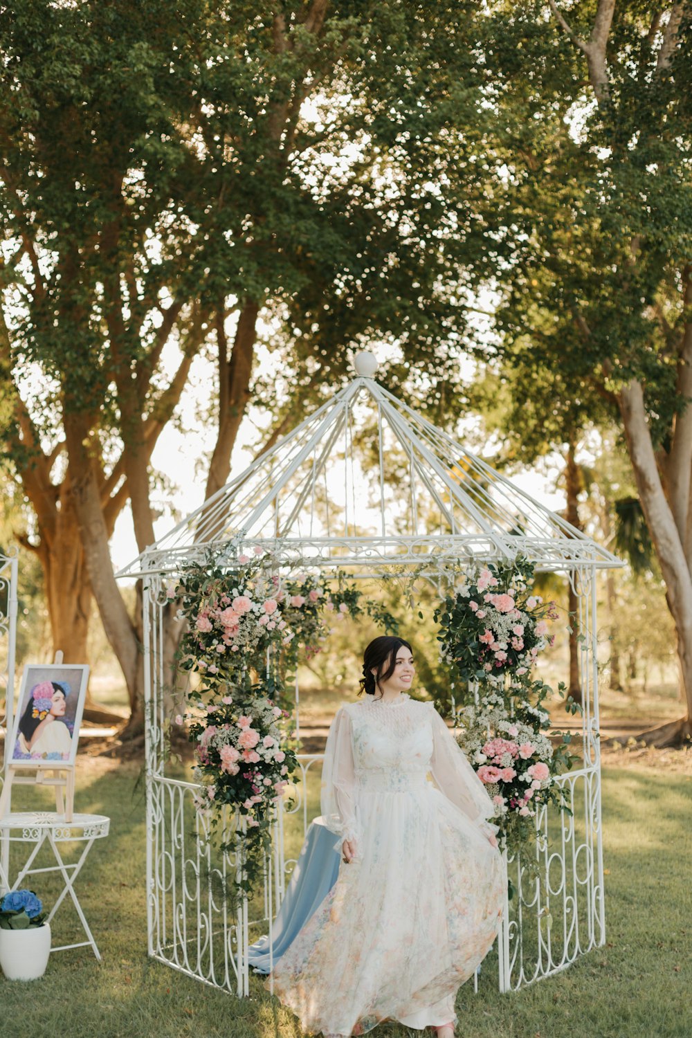 a woman in a white dress standing in front of a white gazebo