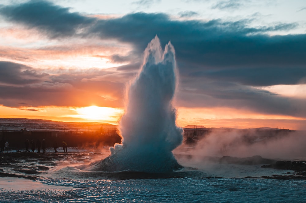a geyser spewing water into the air at sunset