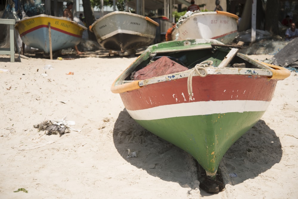 a row of boats sitting on top of a sandy beach