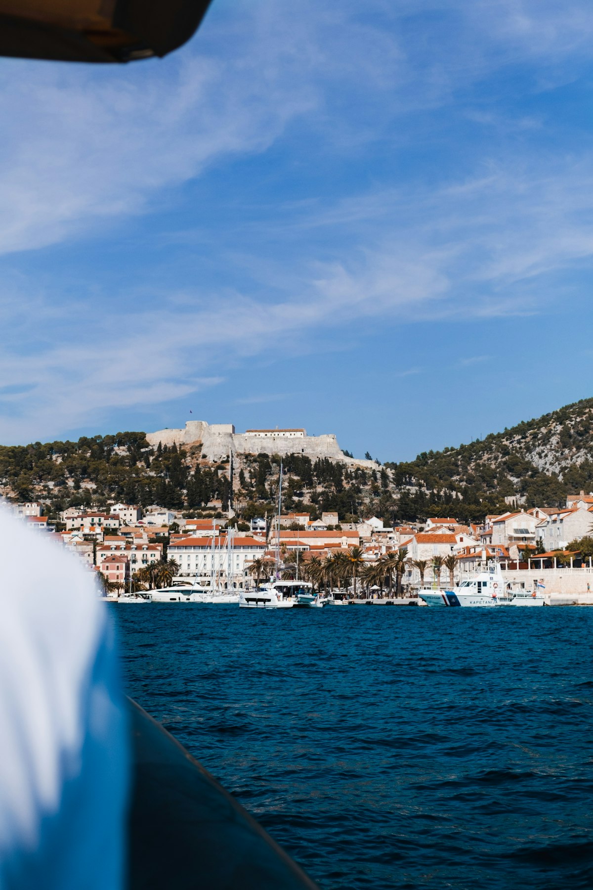 Hvar Town main square and harbour with Spanish Fortress overhead