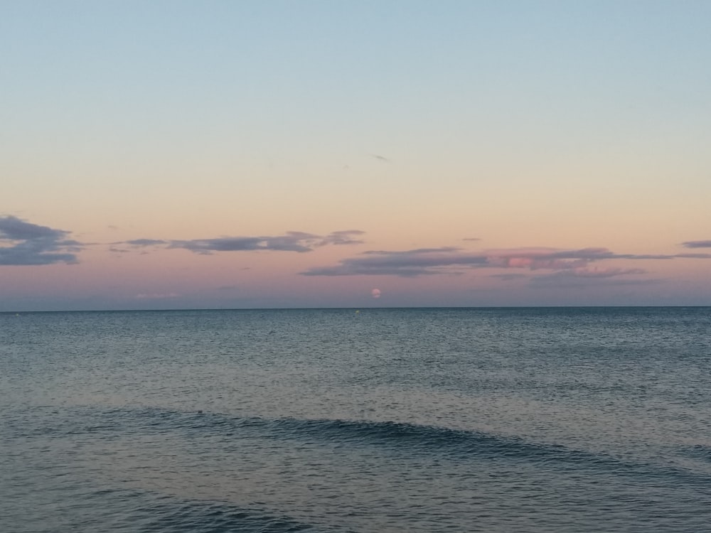 a body of water sitting under a cloudy sky