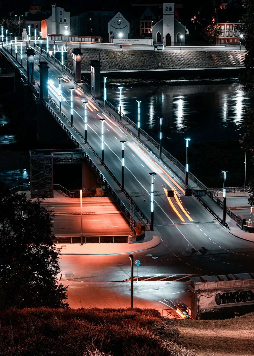 a night time view of a bridge over a river