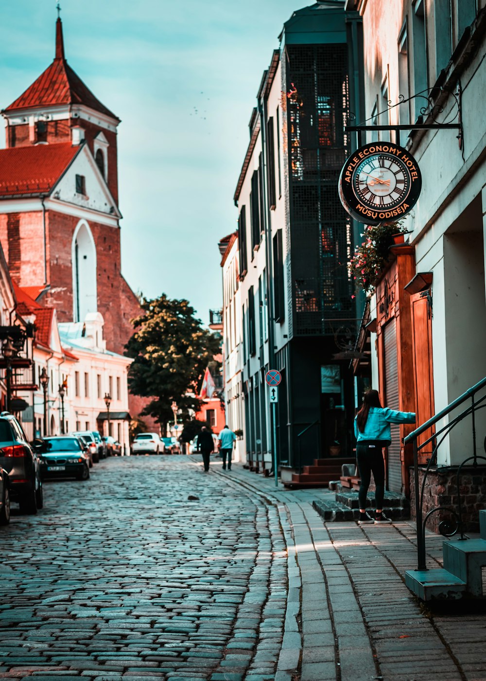 a cobblestone street with a clock tower in the background