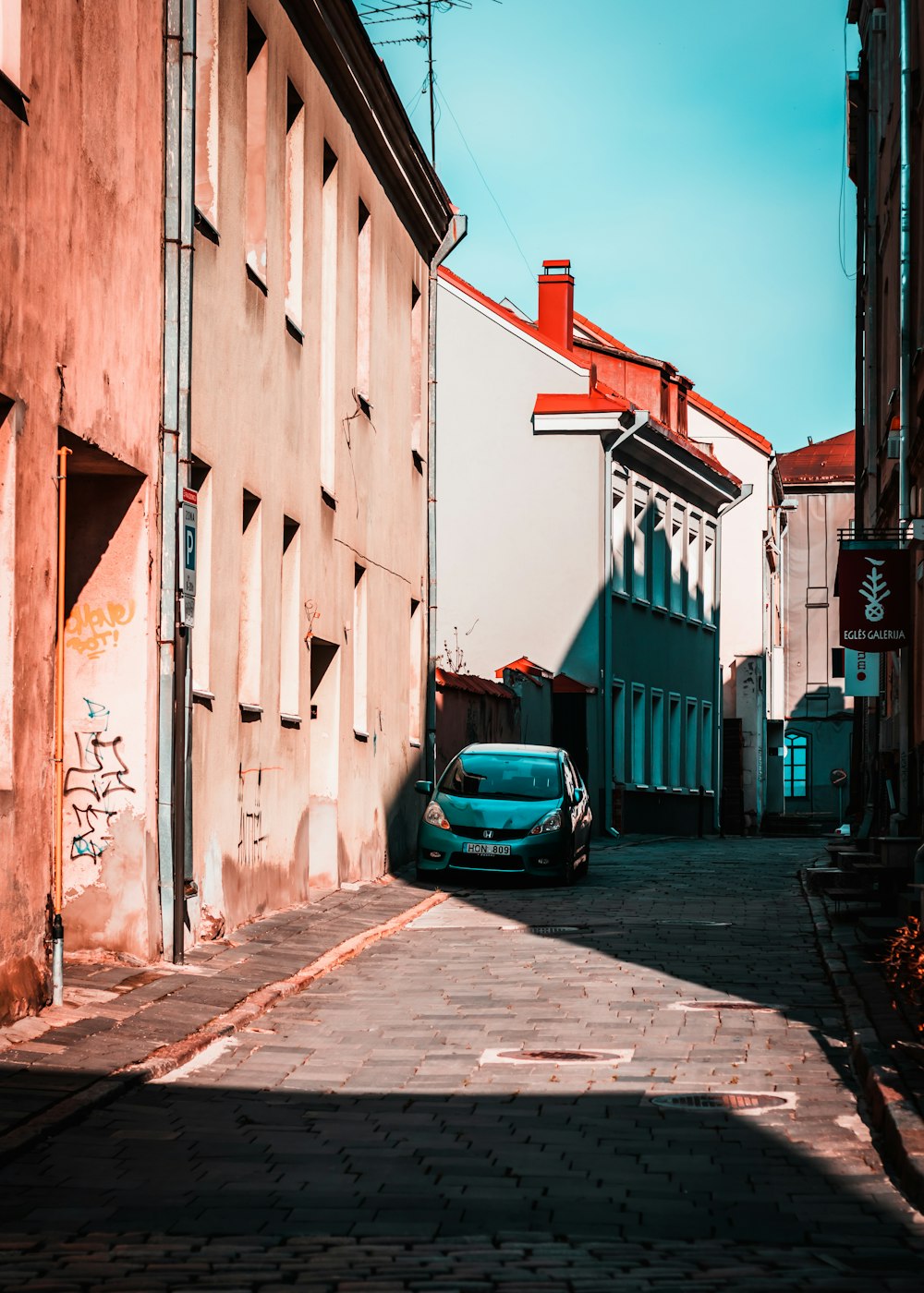 a car parked on the side of a road next to a building