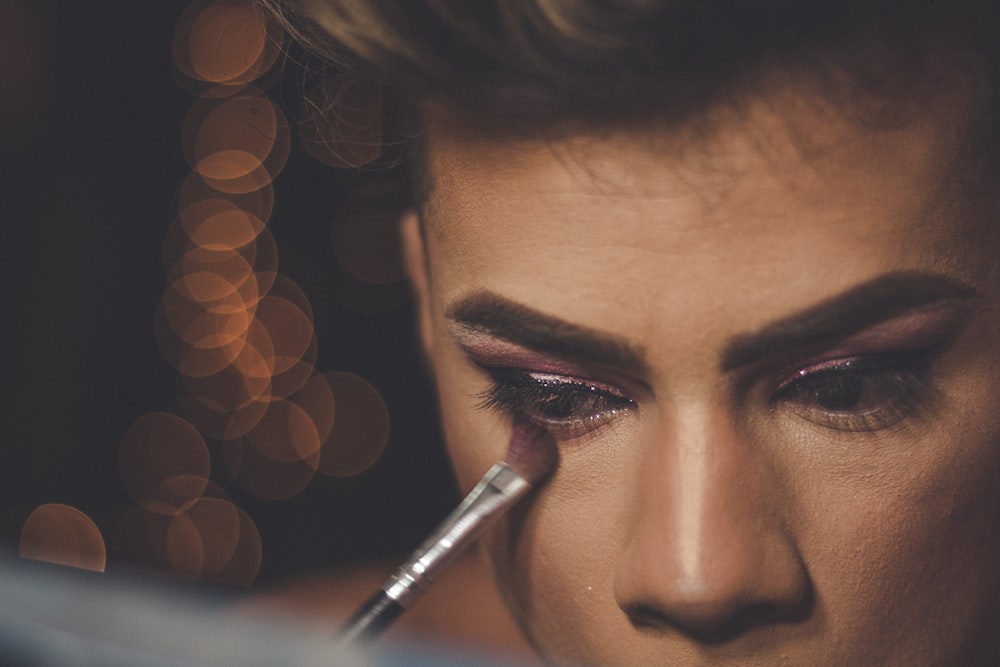 a close up of a woman with a pen in her mouth