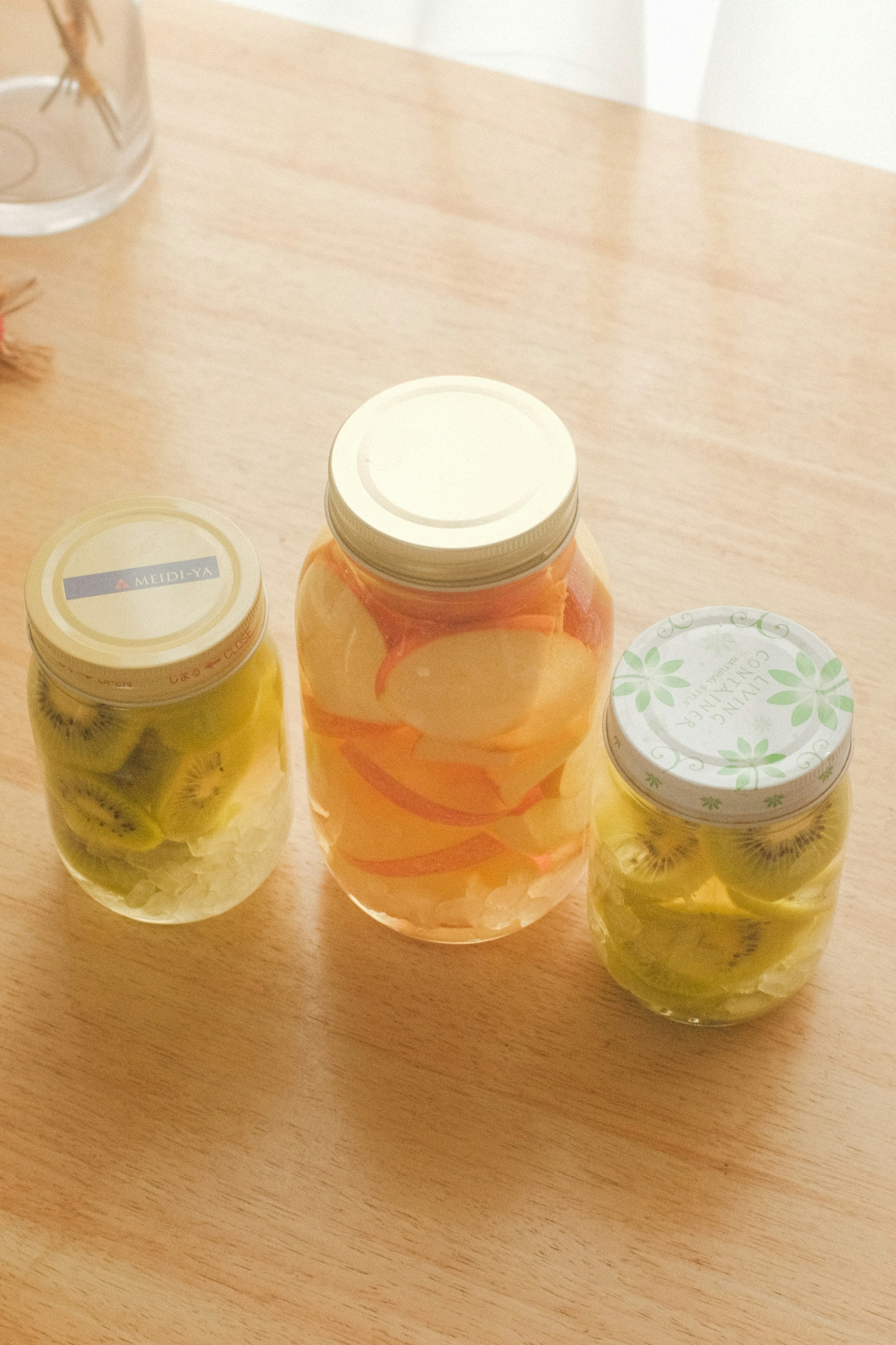 three jars of pickles sitting on a table