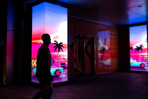 a man walking in front of a display of cars