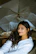 a woman sitting in a chair under an umbrella