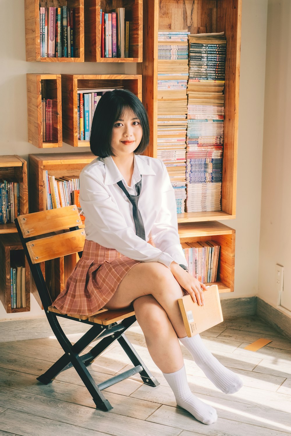 a woman sitting on a chair in front of a bookshelf