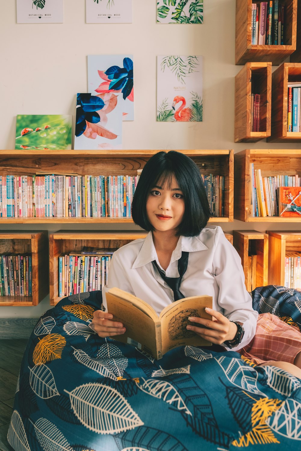 a woman sitting on a bed reading a book