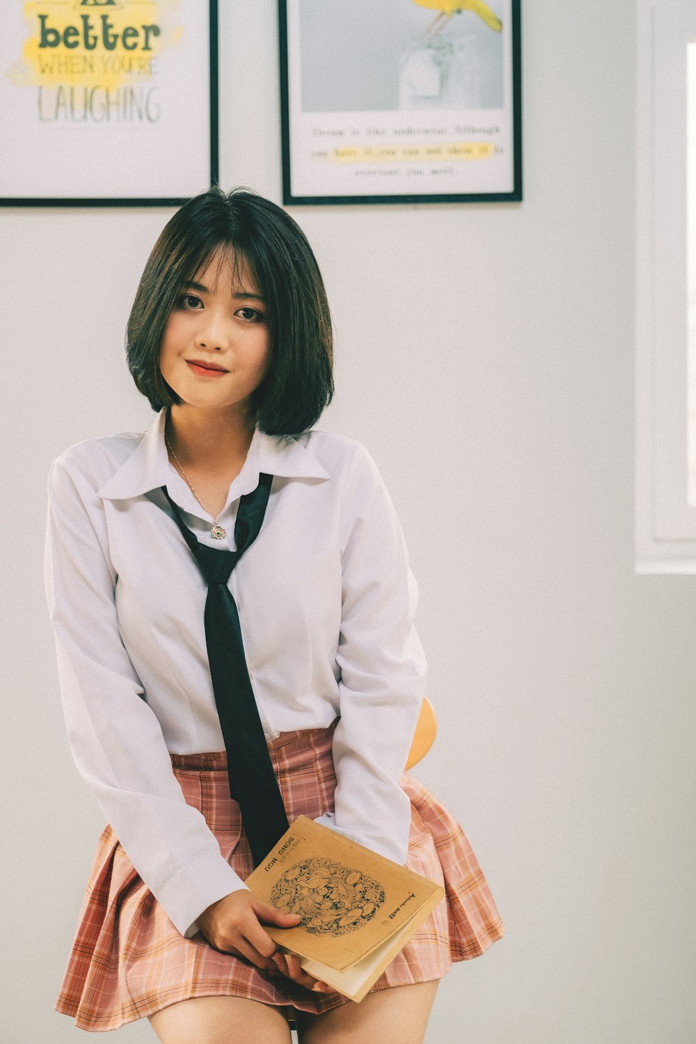 a girl in a school uniform holding a book