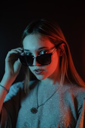 a woman wearing sunglasses and a necklace
