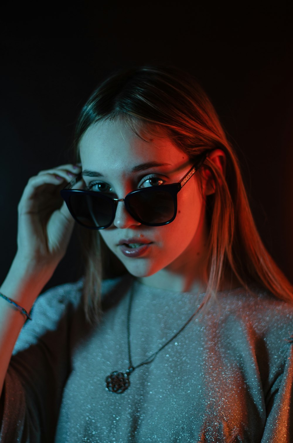 a woman wearing sunglasses and a necklace