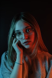 a woman wearing glasses is talking on a cell phone