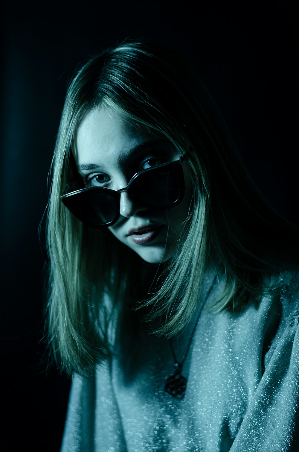 a woman with sunglasses on her face in the dark