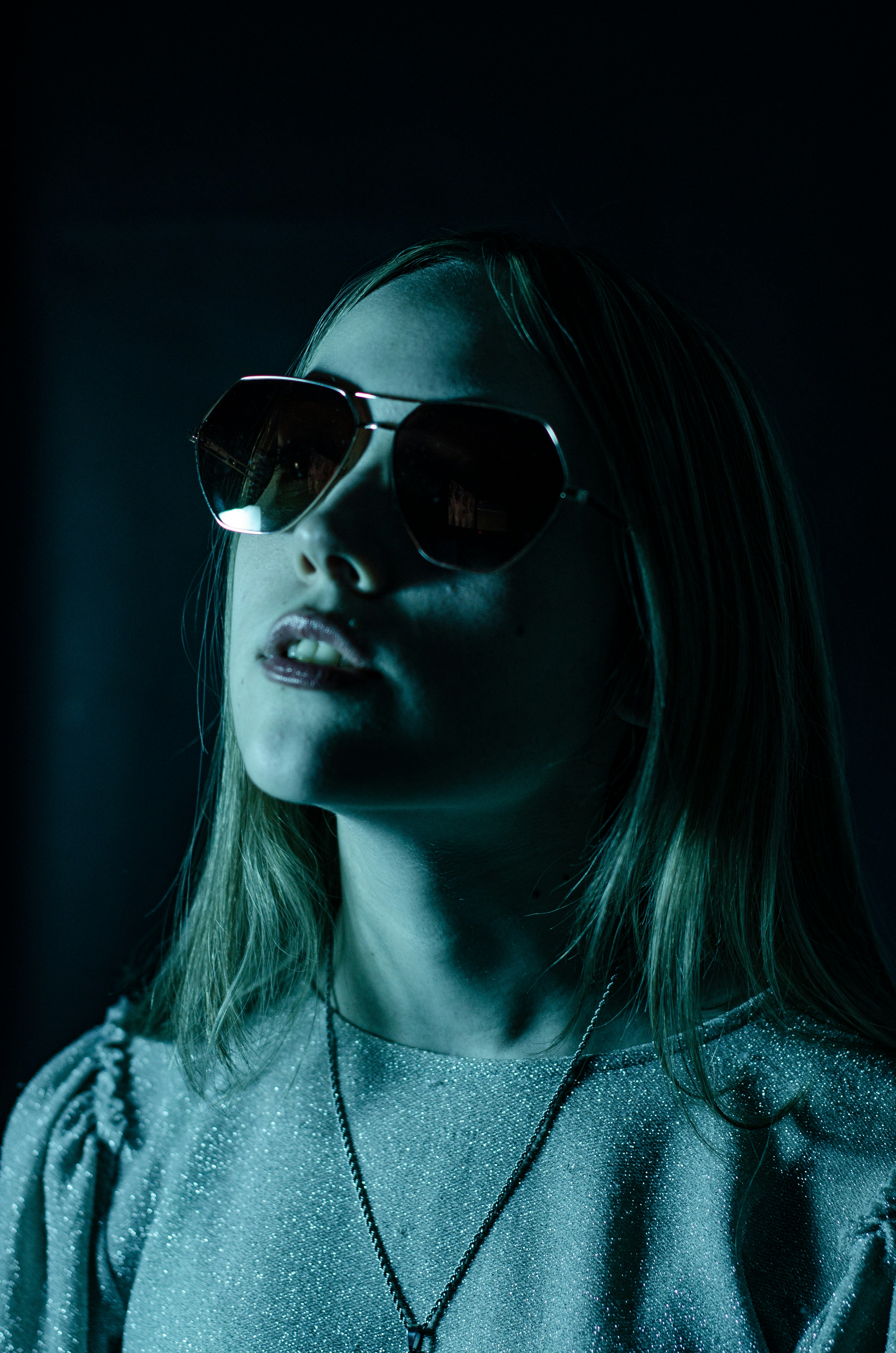 a woman wearing sunglasses in a dark room