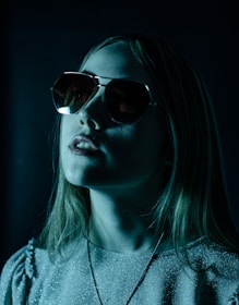 a woman wearing sunglasses in a dark room