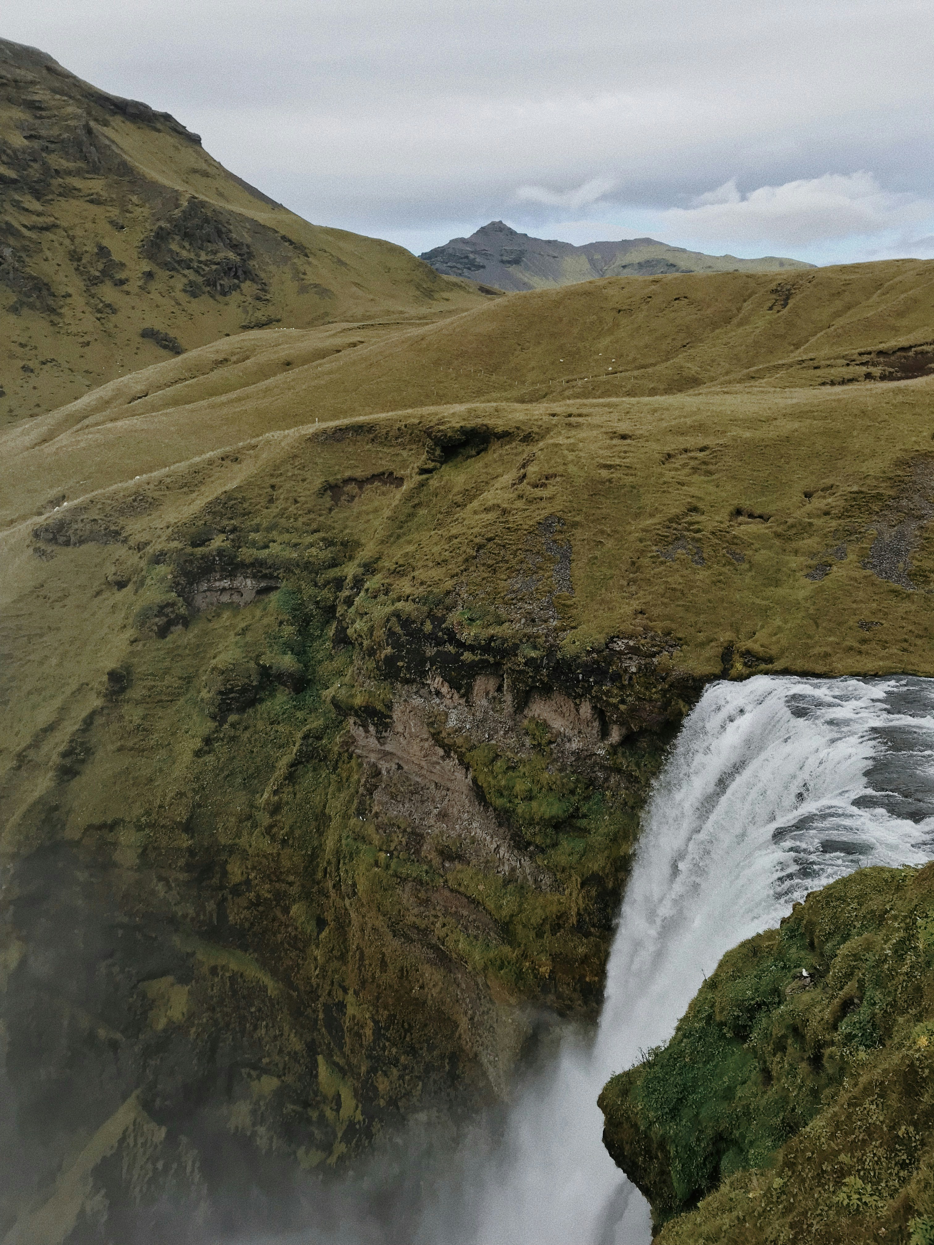 a waterfall in the middle of a grassy area