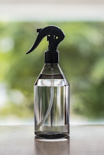 a spray bottle on a table with a blurry background