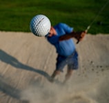 a man hitting a golf ball with a golf club