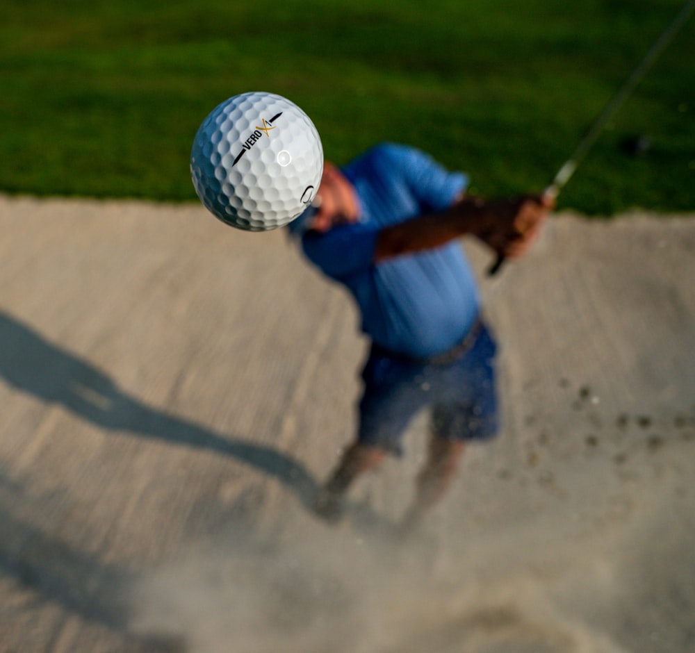 a man hitting a golf ball with a golf club