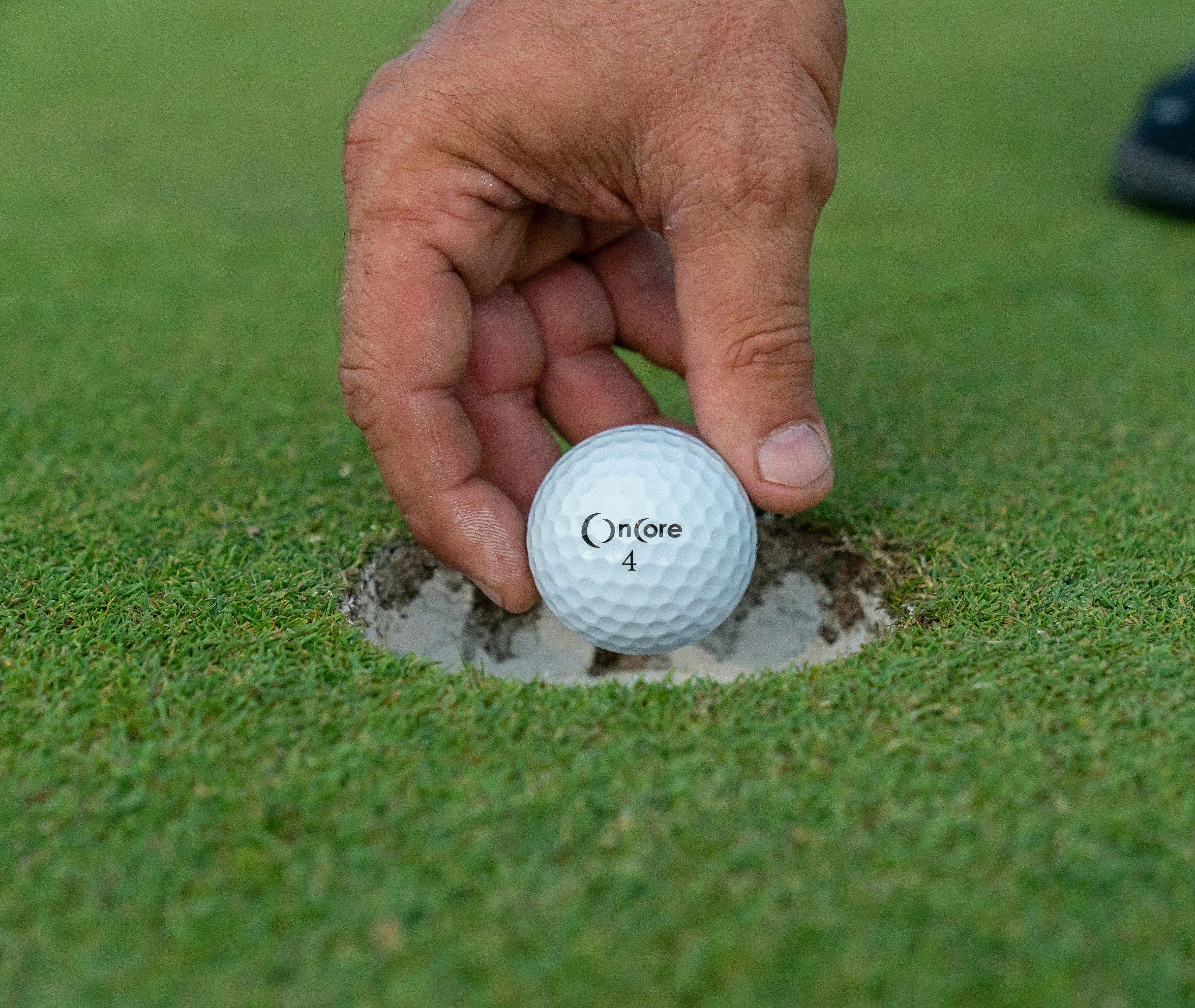 A golfer using a custom golf ball stamper on the course