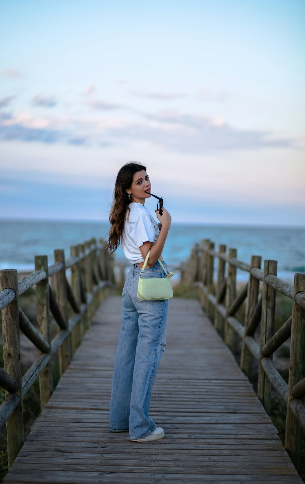 a woman standing on a pier holding a camera