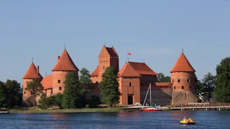 a boat is in the water in front of a castle
