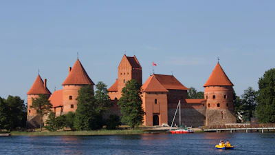Trakai island castle across the lake with a boat in front