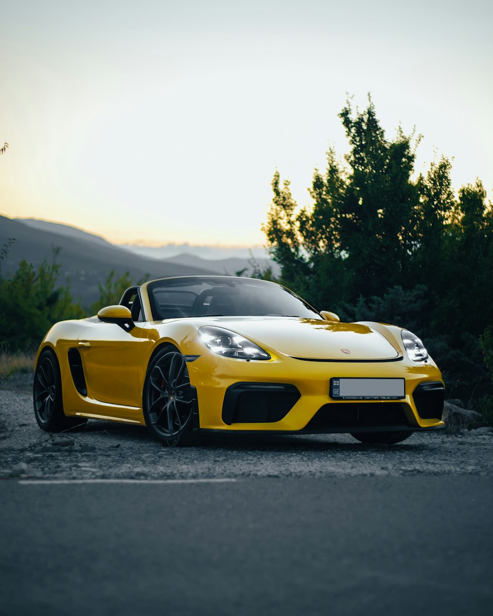 a yellow sports car parked on the side of the road