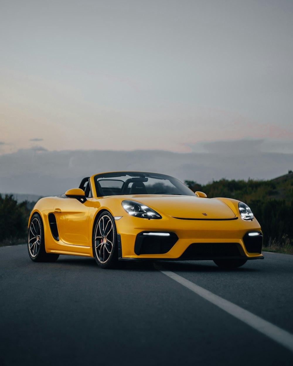 a yellow sports car parked on the side of the road