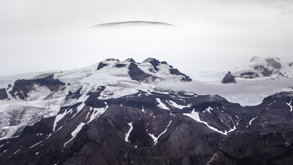 a very tall mountain covered in snow and clouds