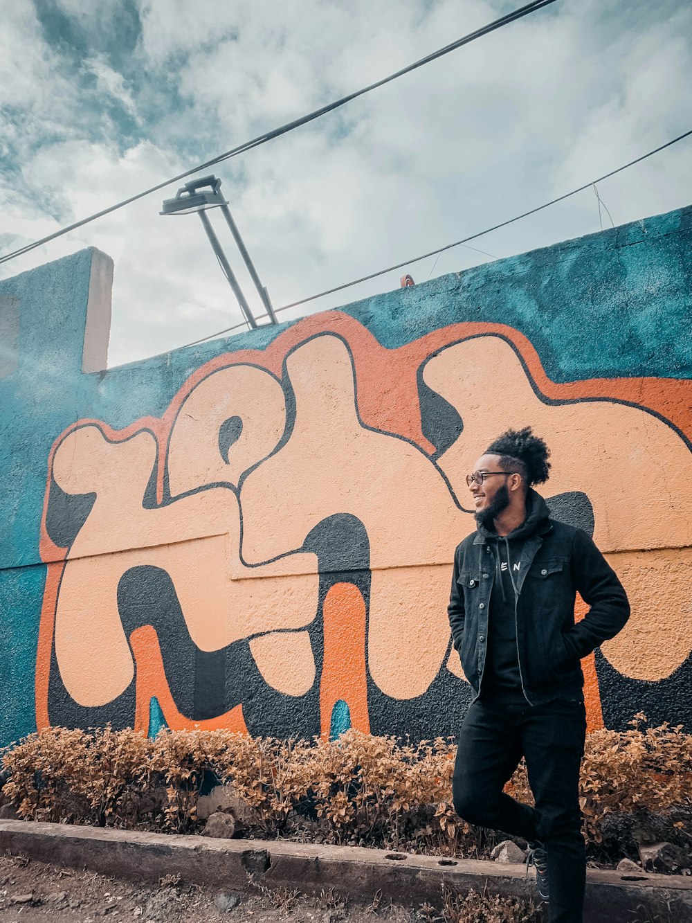 a man standing in front of a colorful wall