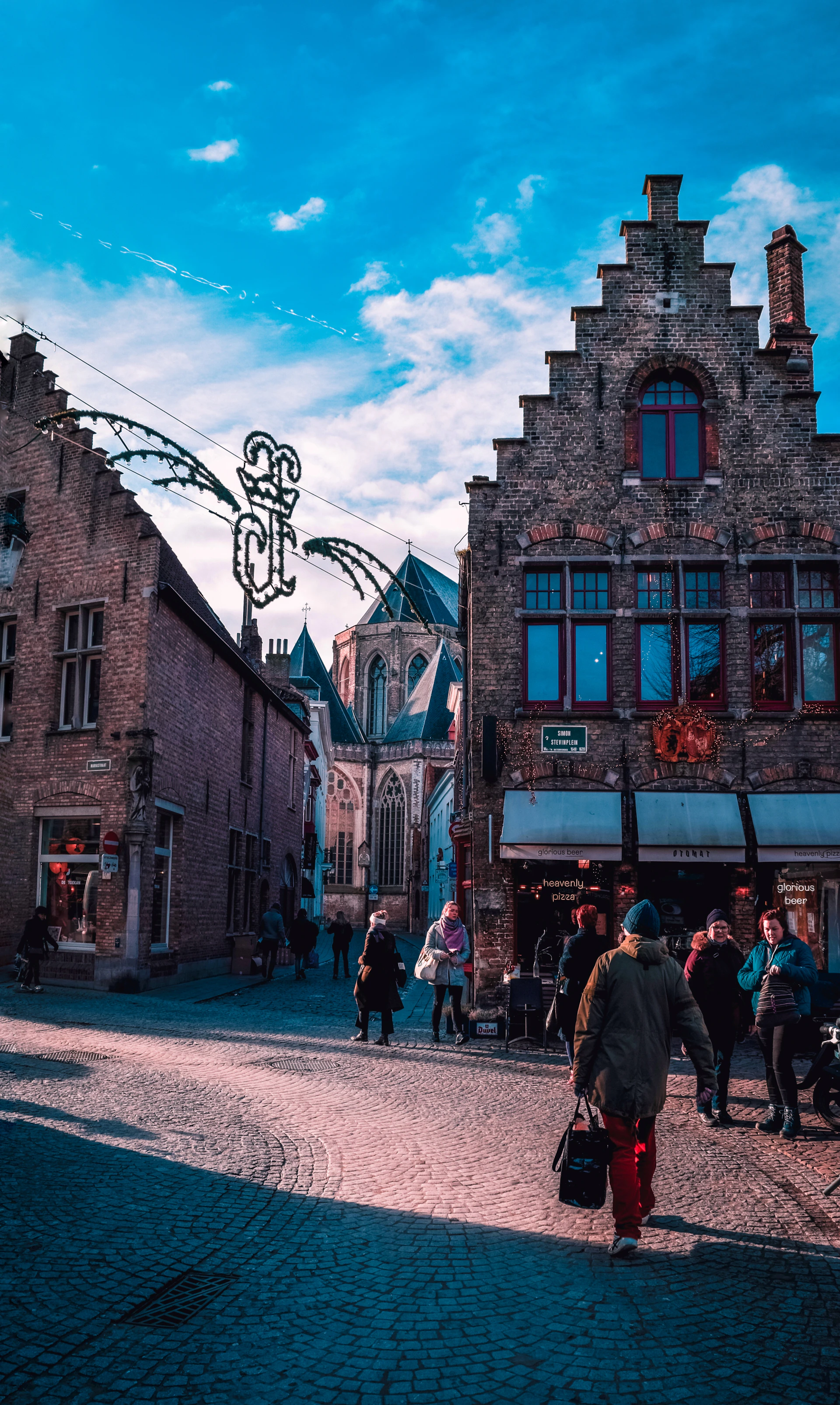 a group of people walking down a cobblestone street