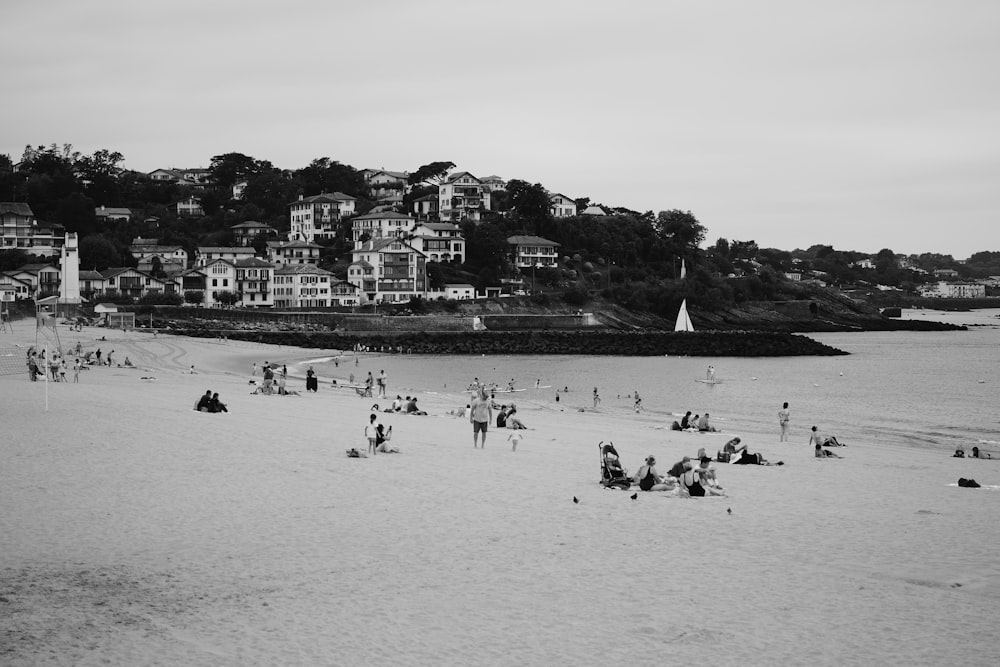 uma foto em preto e branco de pessoas em uma praia