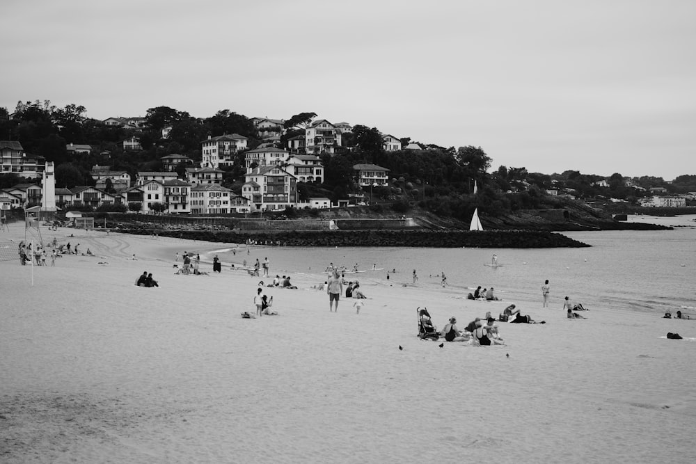 a black and white photo of people on a beach